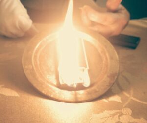 Gold ashtray with a box of matches engulfed in flames.